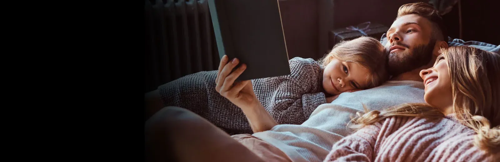 Family reading in bed